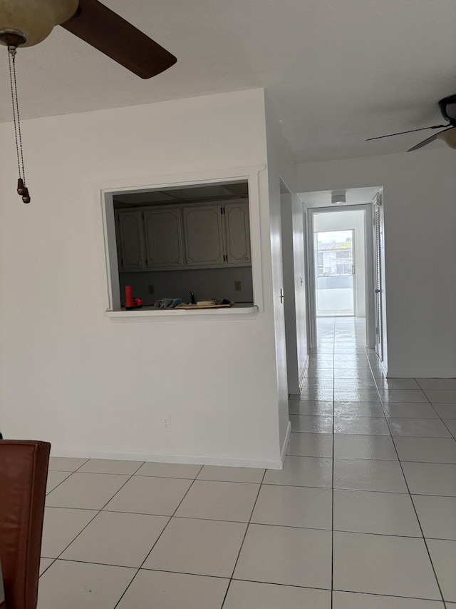 hallway featuring baseboards and tile patterned floors