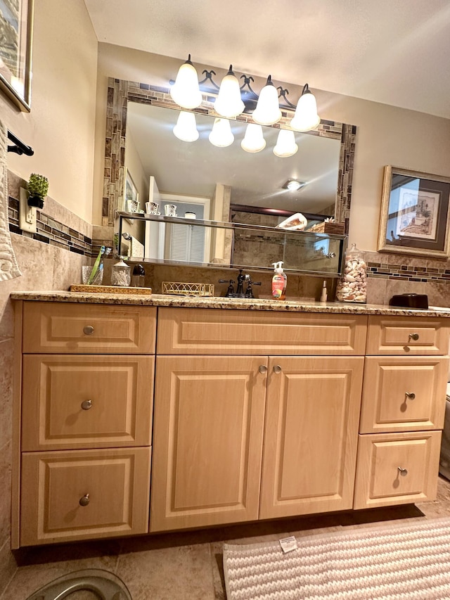 bathroom with double vanity, a sink, and tile walls