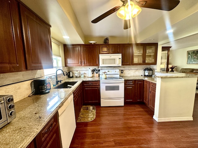 kitchen featuring white appliances, dark wood-style flooring, a sink, light stone countertops, and glass insert cabinets