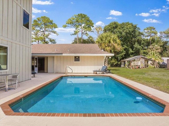 pool featuring a yard, an outdoor structure, and a patio