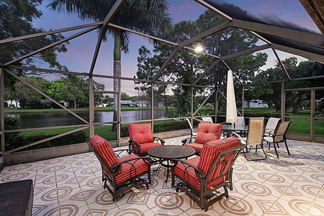 patio terrace at dusk with a lanai and a water view