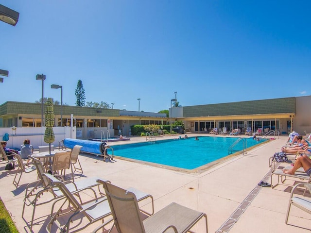 community pool featuring a patio and fence