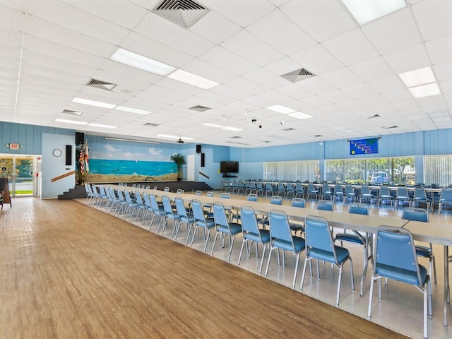 interior space with a drop ceiling, visible vents, and wood finished floors