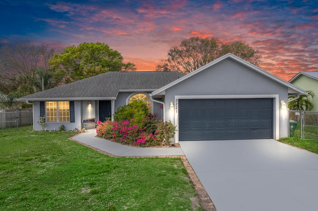 single story home featuring a garage, fence, a yard, driveway, and stucco siding