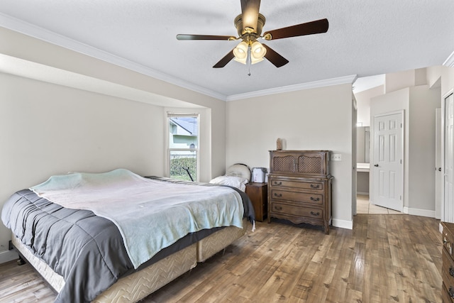 bedroom with baseboards, a ceiling fan, wood finished floors, crown molding, and a textured ceiling