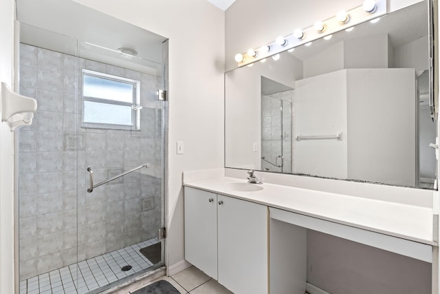 full bath with a stall shower, vanity, and tile patterned floors