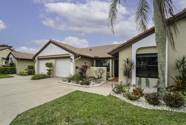 view of front of property featuring an attached garage, driveway, a tile roof, and stucco siding