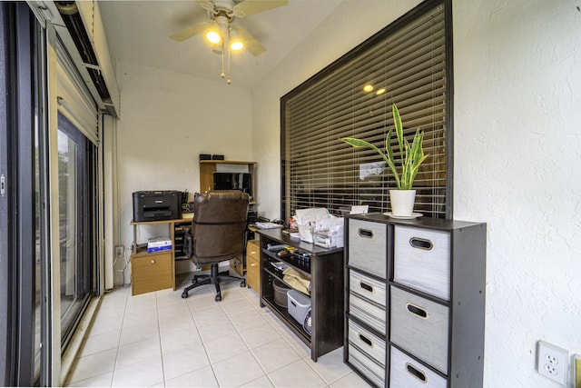 office space featuring a textured wall, ceiling fan, and light tile patterned flooring