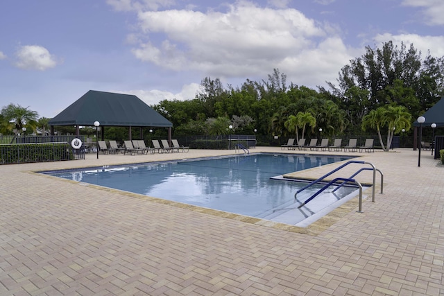 pool with a gazebo, a patio area, and fence