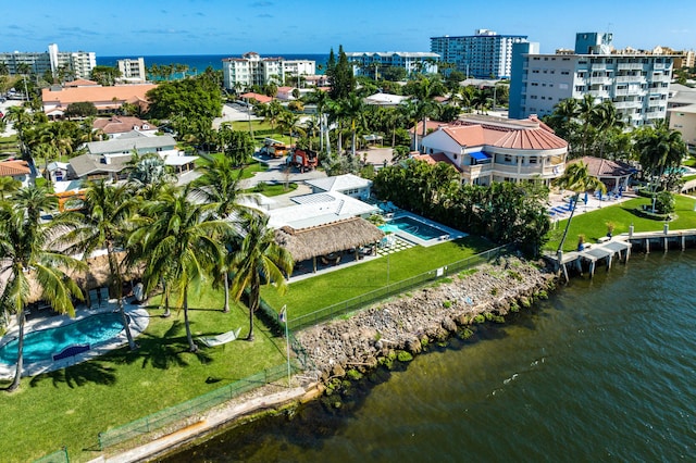 drone / aerial view of a nearby body of water and a pool area