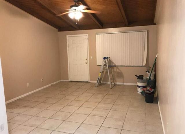 interior space with wood ceiling, baseboards, a ceiling fan, and light tile patterned flooring