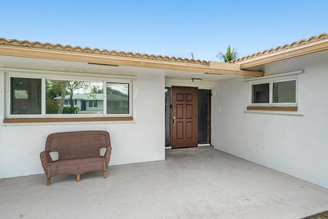 doorway to property featuring a patio and stucco siding