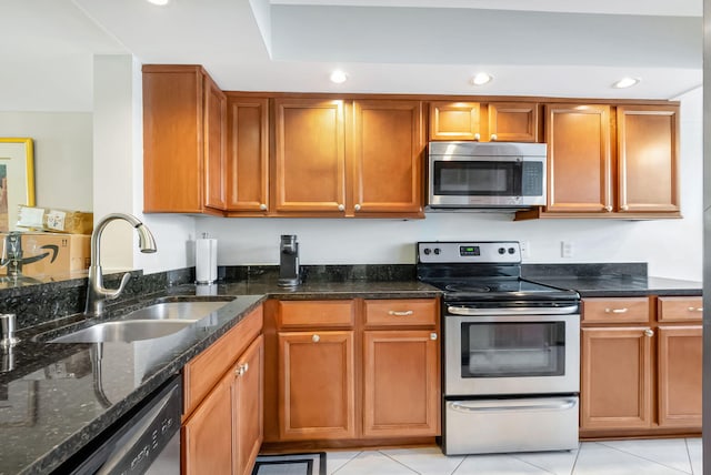 kitchen with stainless steel appliances, brown cabinets, and a sink