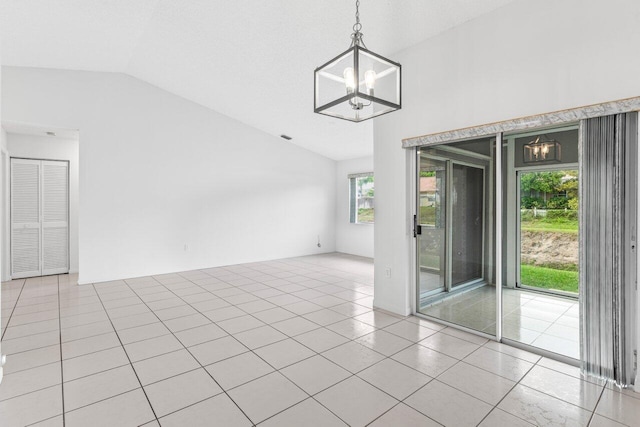 unfurnished room with lofted ceiling, light tile patterned flooring, and an inviting chandelier