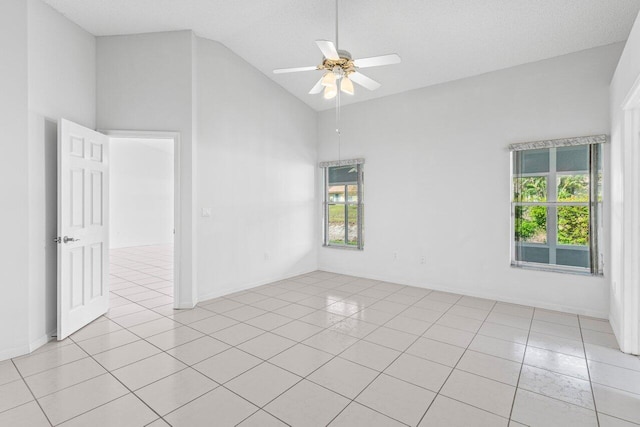 empty room featuring light tile patterned floors, high vaulted ceiling, and a ceiling fan