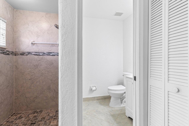 bathroom with a closet, visible vents, toilet, vanity, and tiled shower