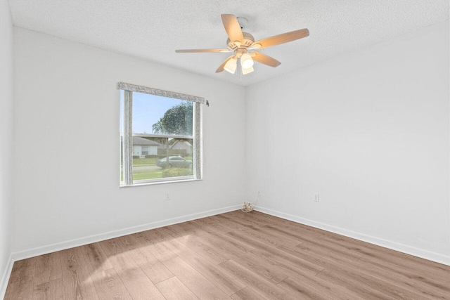 unfurnished room with a textured ceiling, ceiling fan, baseboards, and light wood-style floors