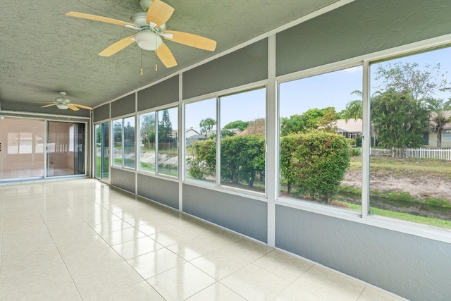 unfurnished sunroom with ceiling fan