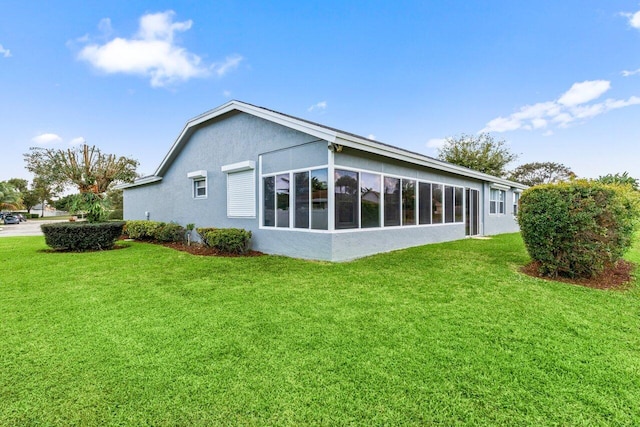 rear view of property with a yard and stucco siding