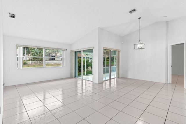 unfurnished room with a chandelier, lofted ceiling, visible vents, and light tile patterned floors