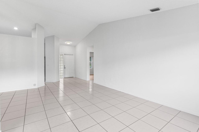 unfurnished room with lofted ceiling, visible vents, and light tile patterned floors