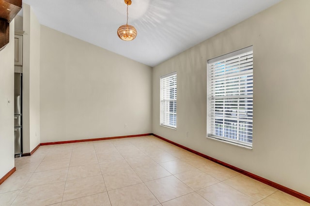 spare room with light tile patterned flooring and baseboards