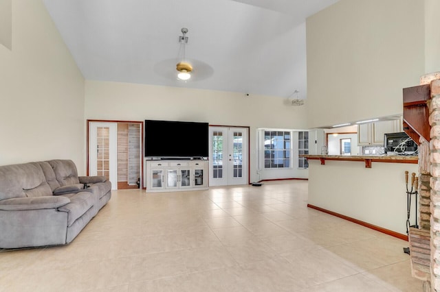 living area with light tile patterned floors, high vaulted ceiling, french doors, and ceiling fan