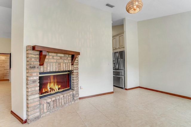 unfurnished living room with a brick fireplace, baseboards, light tile patterned floors, and visible vents