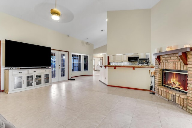 living room with french doors, light tile patterned floors, a brick fireplace, high vaulted ceiling, and baseboards