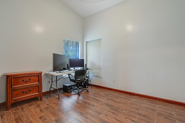 home office with high vaulted ceiling, baseboards, and wood finished floors