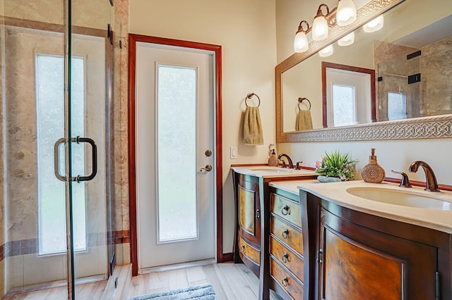 full bath with wood finished floors, plenty of natural light, a sink, and a shower stall