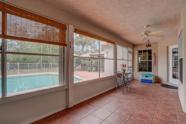 unfurnished sunroom featuring a ceiling fan