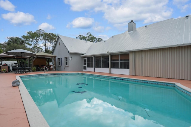 outdoor pool featuring a gazebo, a patio, and a sunroom