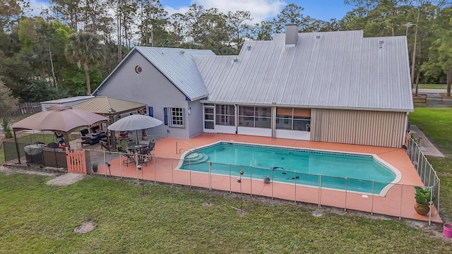 outdoor pool with a gazebo, a yard, a patio area, and fence