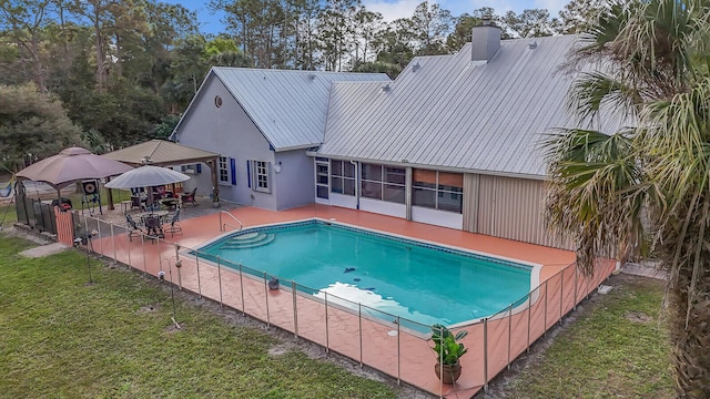 view of swimming pool with a patio area, a fenced in pool, fence, and a lawn