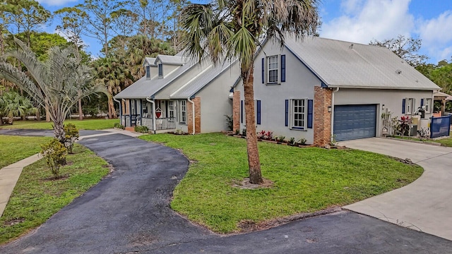 view of front of house with driveway, covered porch, a front lawn, and brick siding