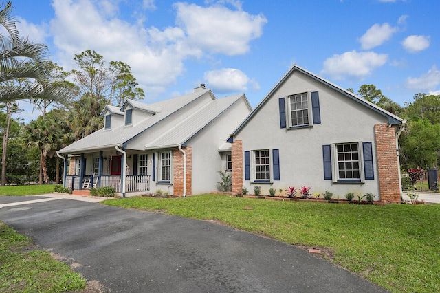 view of front of property with stucco siding, a front lawn, a porch, and brick siding