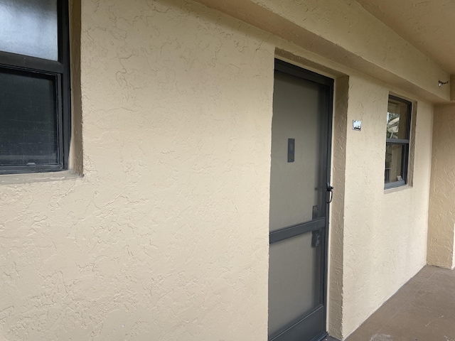 doorway to property featuring stucco siding