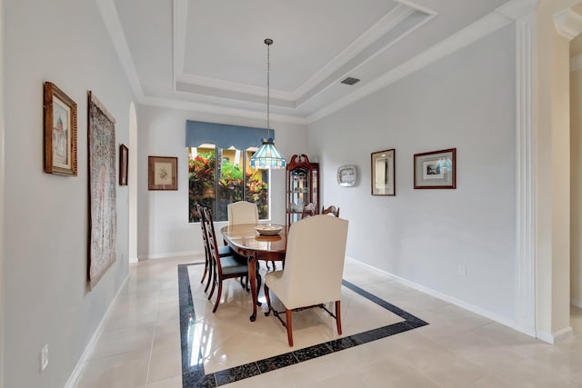 dining space with visible vents, baseboards, a raised ceiling, and ornamental molding