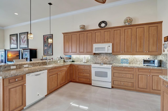 kitchen featuring white appliances, brown cabinetry, decorative light fixtures, crown molding, and a sink