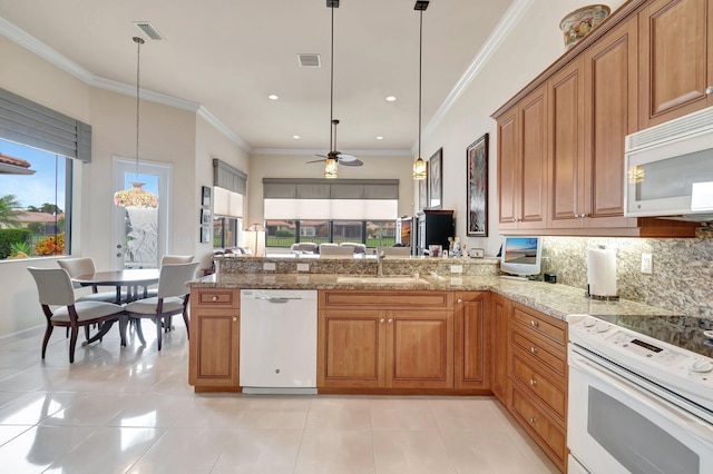 kitchen with pendant lighting, white appliances, a sink, and a peninsula