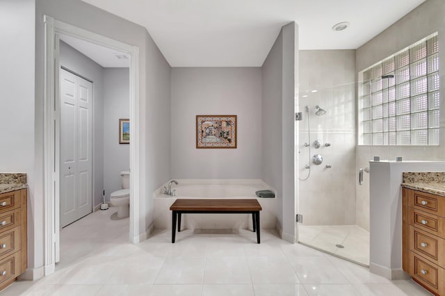 full bath with a closet, toilet, vanity, a shower stall, and tile patterned flooring