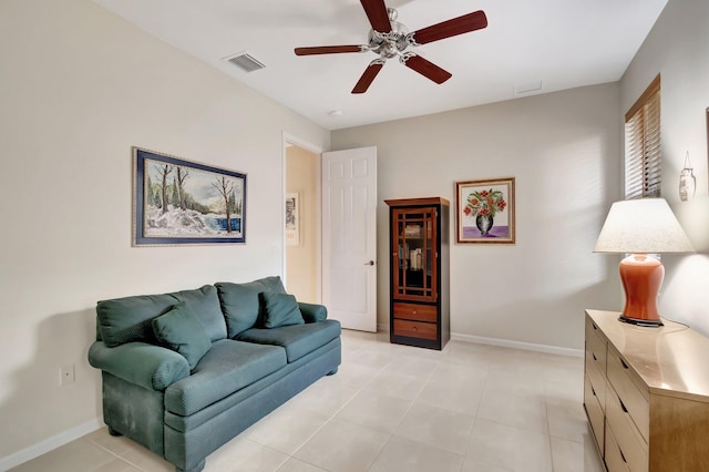 living area with visible vents, ceiling fan, baseboards, and light tile patterned floors