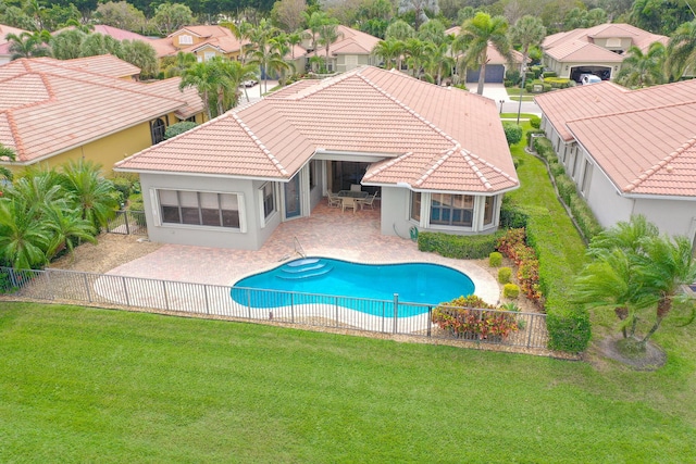 view of swimming pool with a fenced backyard, a yard, a residential view, a fenced in pool, and a patio area