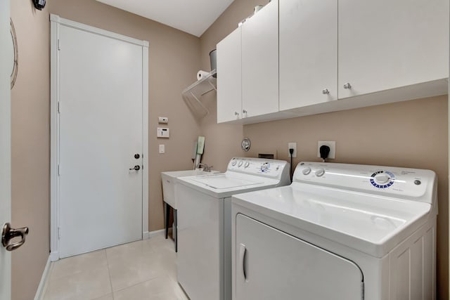 washroom with cabinet space, light tile patterned floors, baseboards, and independent washer and dryer