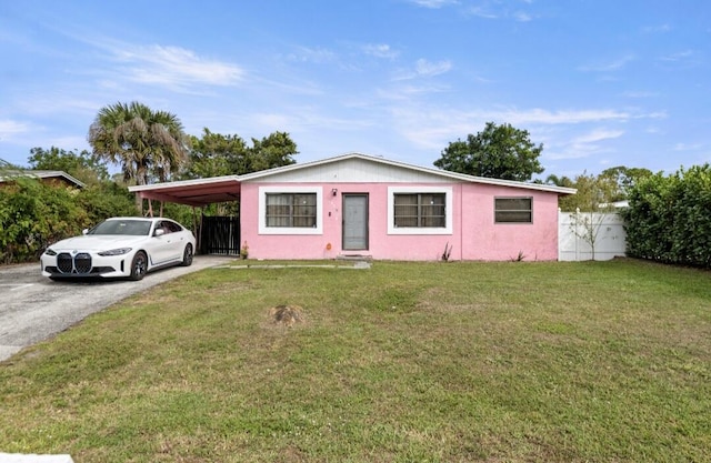 view of front of home with an attached carport, a front lawn, fence, and aphalt driveway