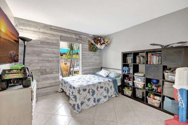 bedroom with tile patterned flooring and wood walls