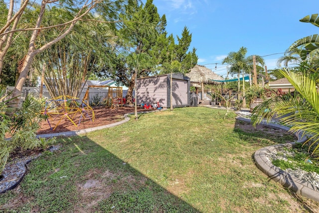 view of yard with a storage shed, an outbuilding, and a fenced backyard