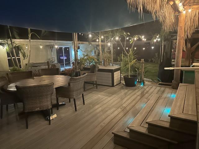 deck at twilight with outdoor dining area