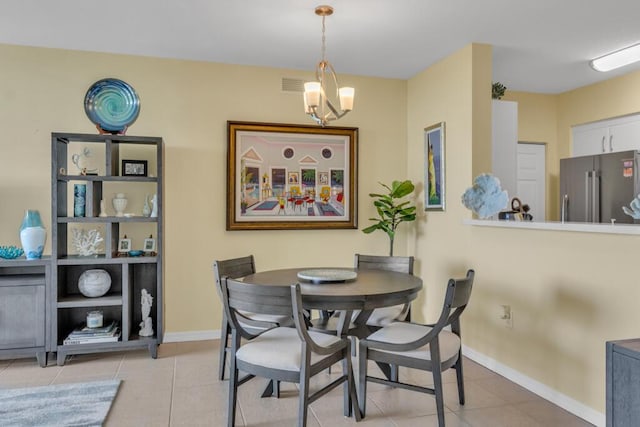 dining room with light tile patterned floors, a notable chandelier, visible vents, and baseboards